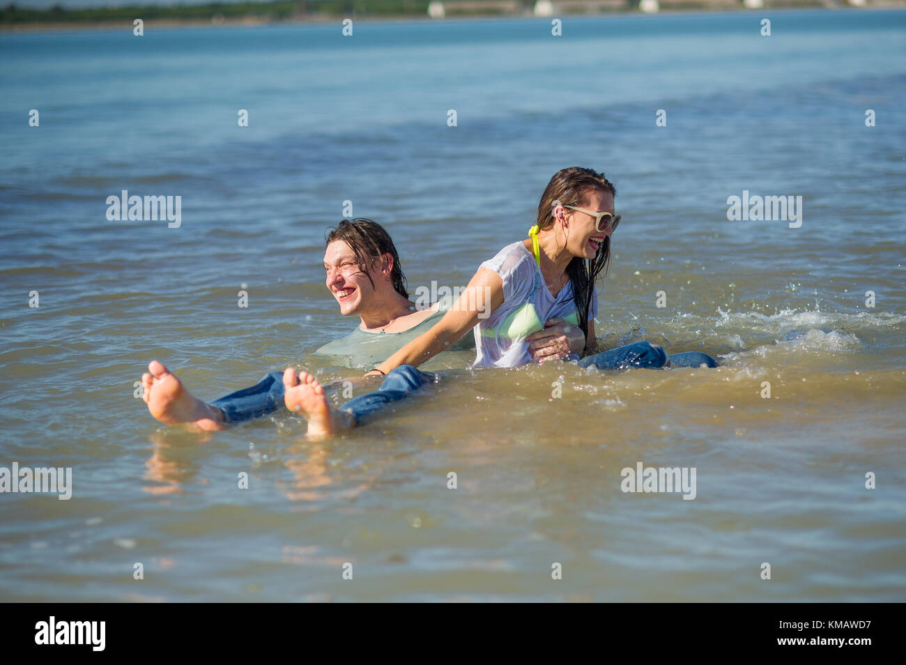 Young couple bathing in the sea. Guy and girl are merrily floundering