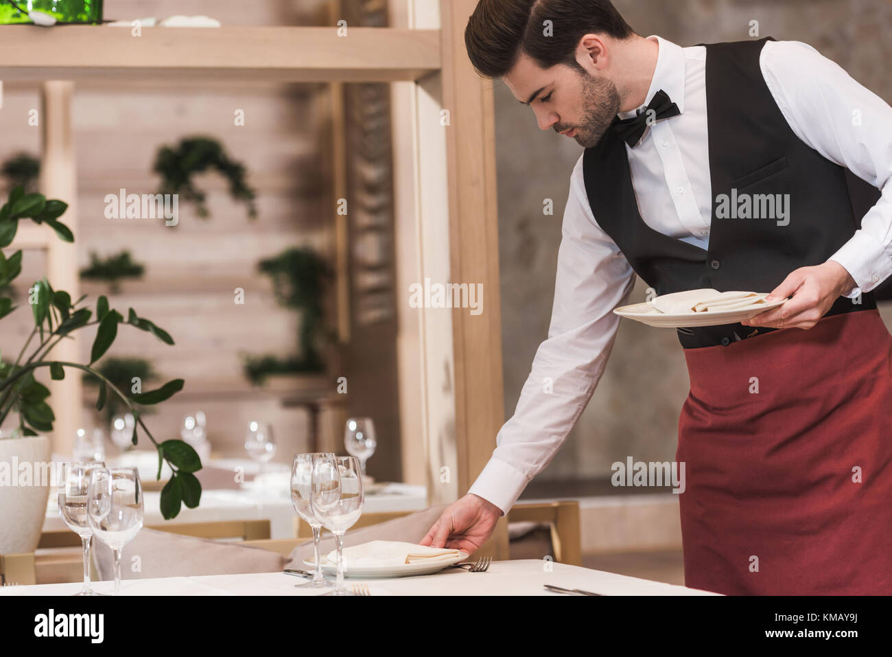 Waiter serving plates on table Stock Photo Alamy
