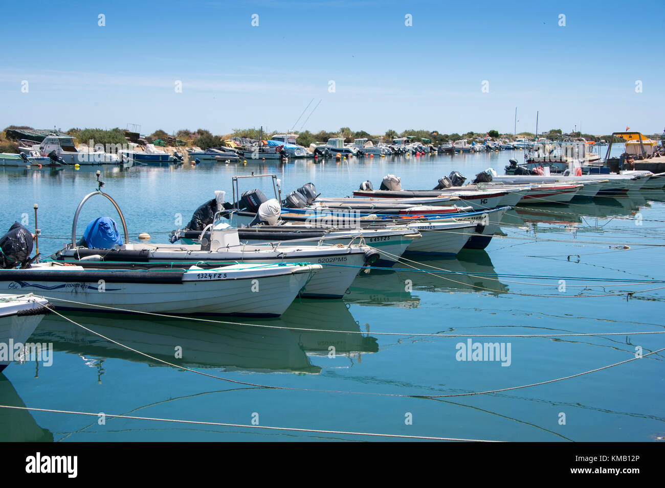 small fishing boats moored along the shore in Fuseta on the Ria Formosa, Portugal. Stock Photo