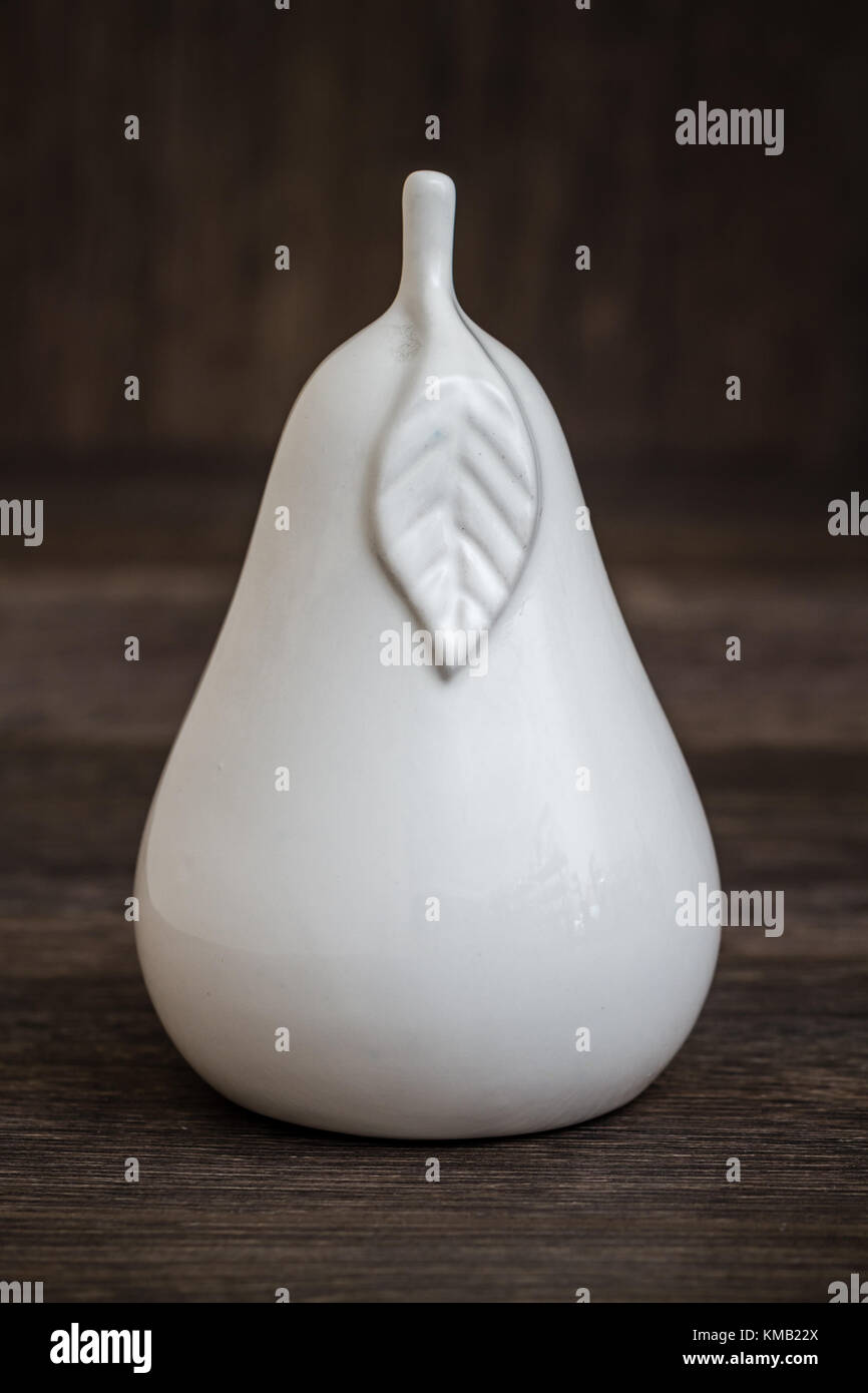 Decorative white ceramic pear shaped trinket on brown background Stock