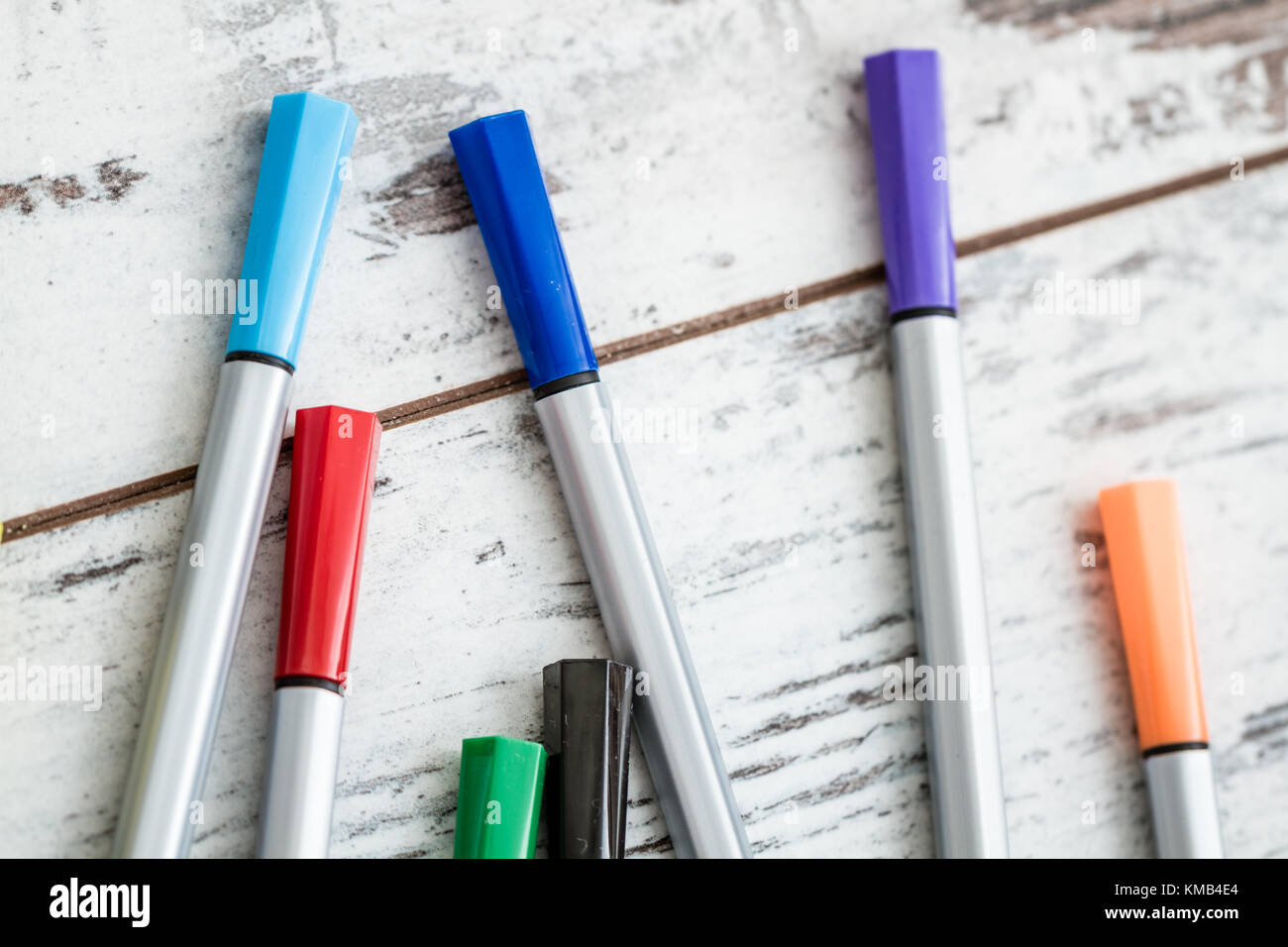 Colorful dispersed felt tip pens on white wooden background Stock Photo ...