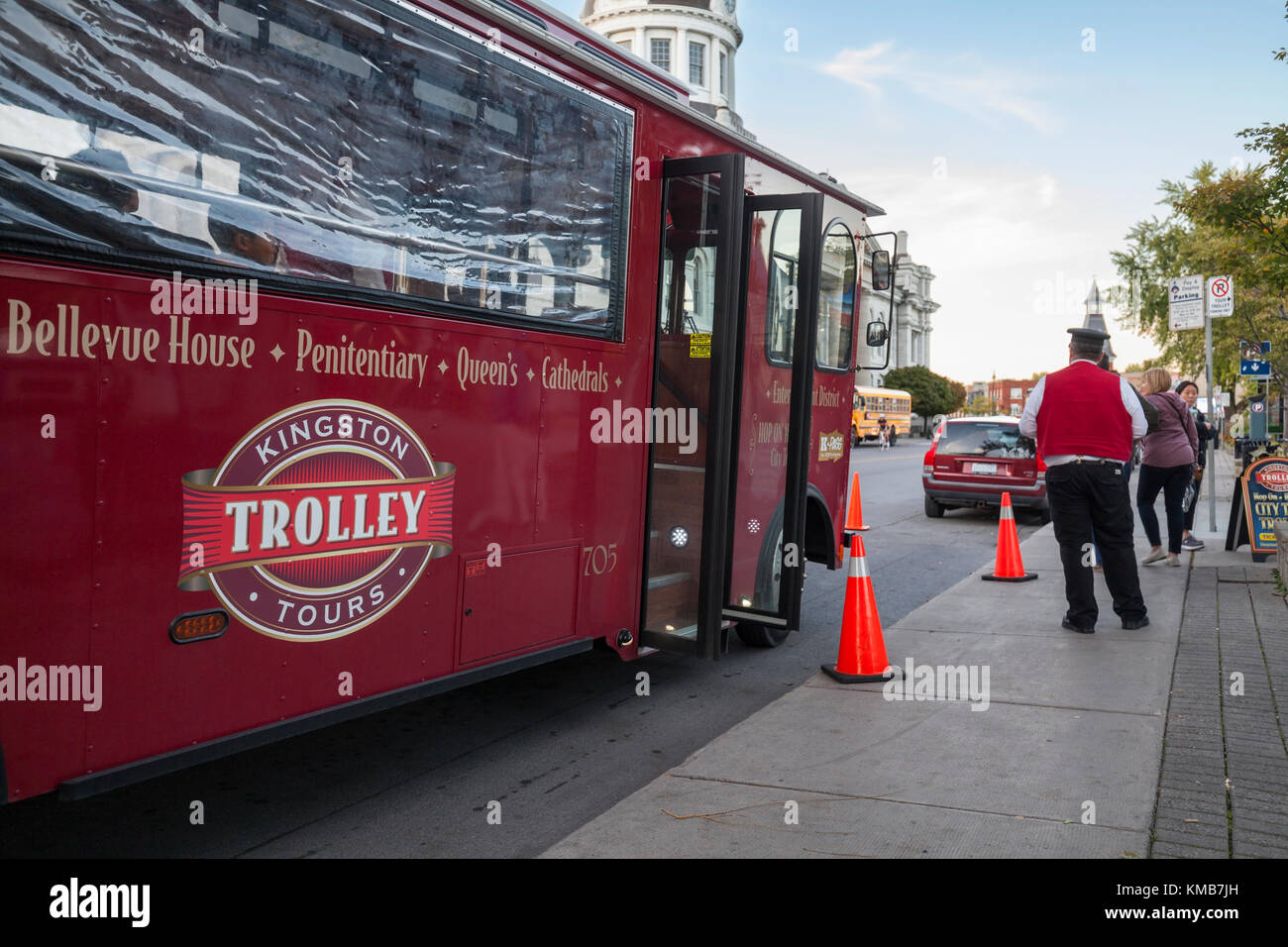 Kingston Trolley tours bus and it's conductor is a Hop On Hop Off bus in Kingston, Ontario, Canada. Stock Photo