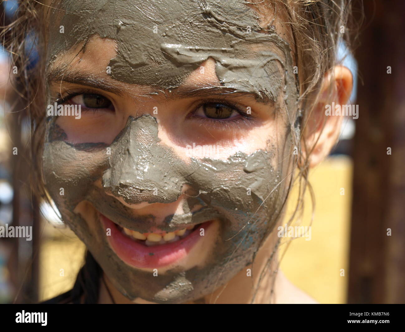 happy smiling girl with mineral mud on her face Stock Photo