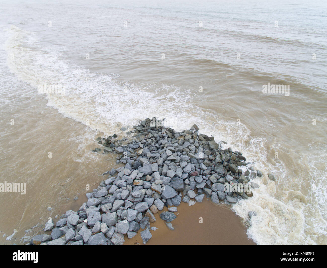 Aerial view of sea waves hitting rocks on the beach in Pantai cahaya ...