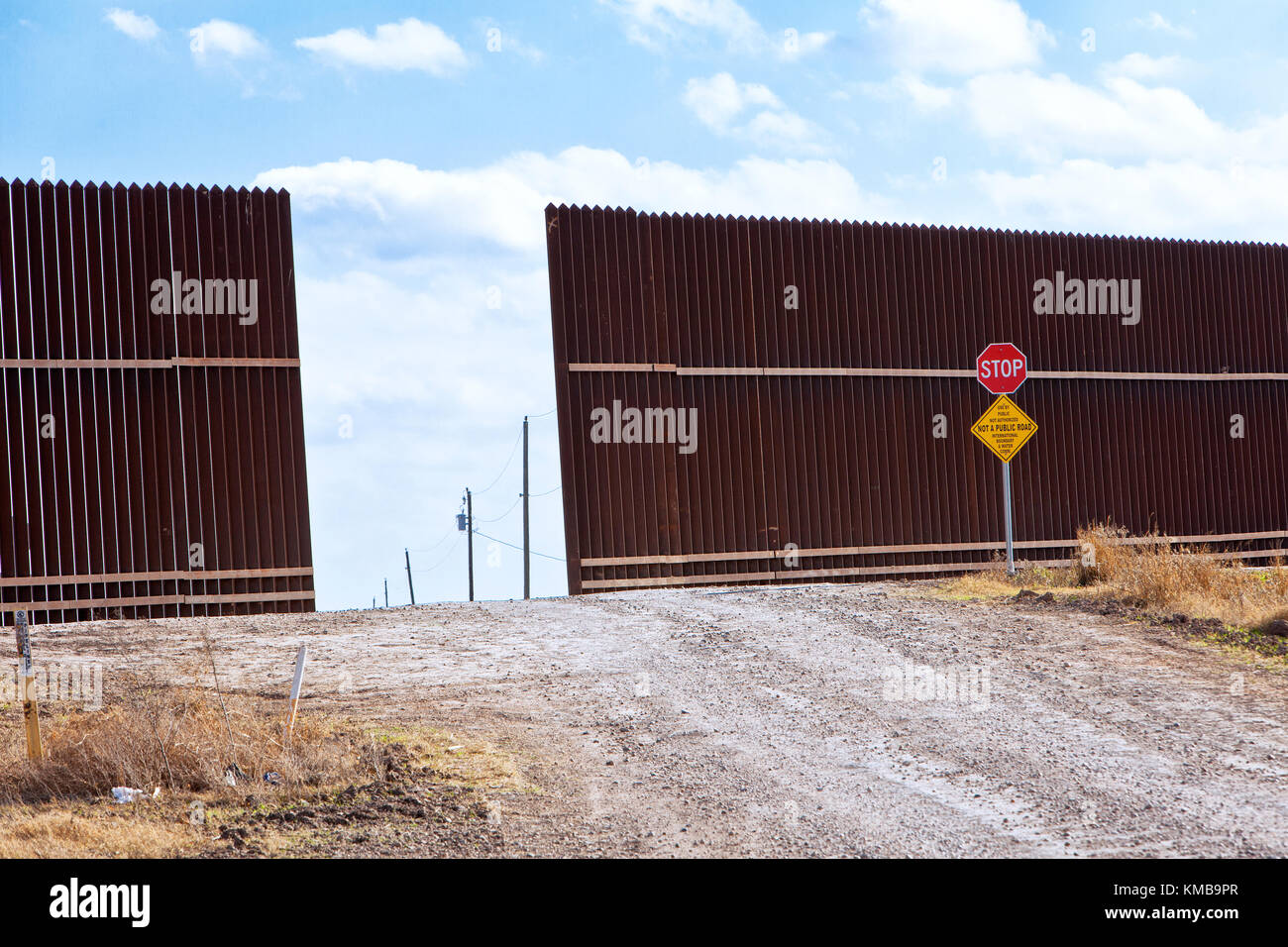 Security border fence with access port to facilitate private agricultural fields that are being utilized for growing crops. Stock Photo