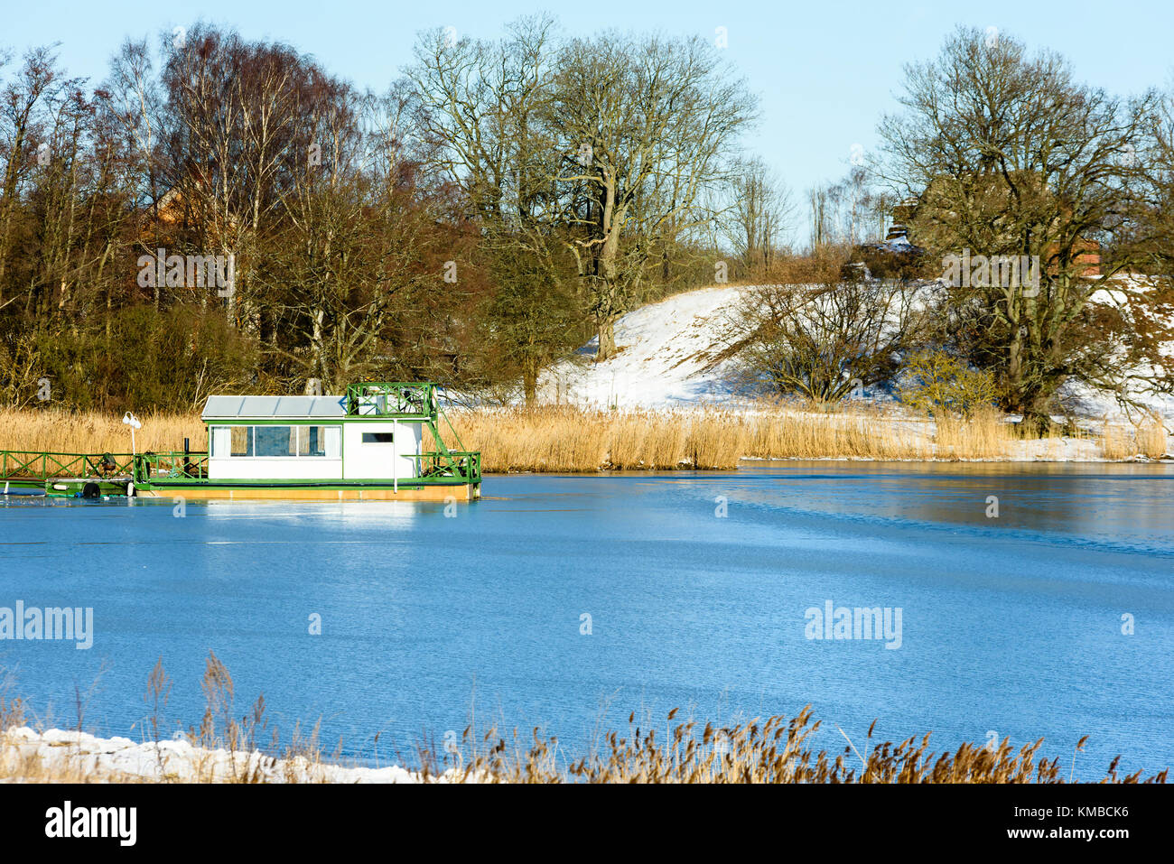 Small Green And White Floating Cabin Moored At A Jetty In Winter