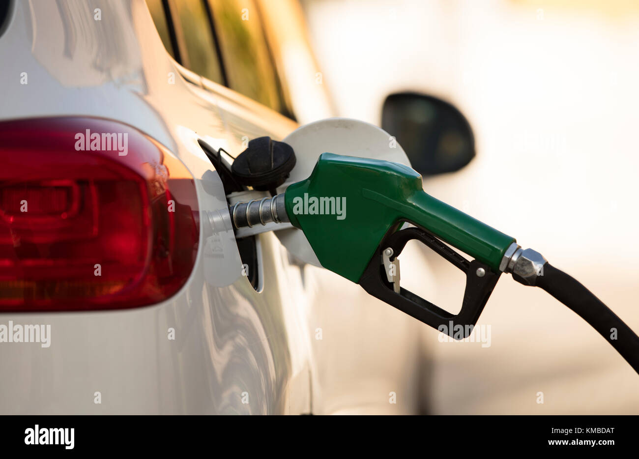 white car at gas station being filled with fuel Stock Photo