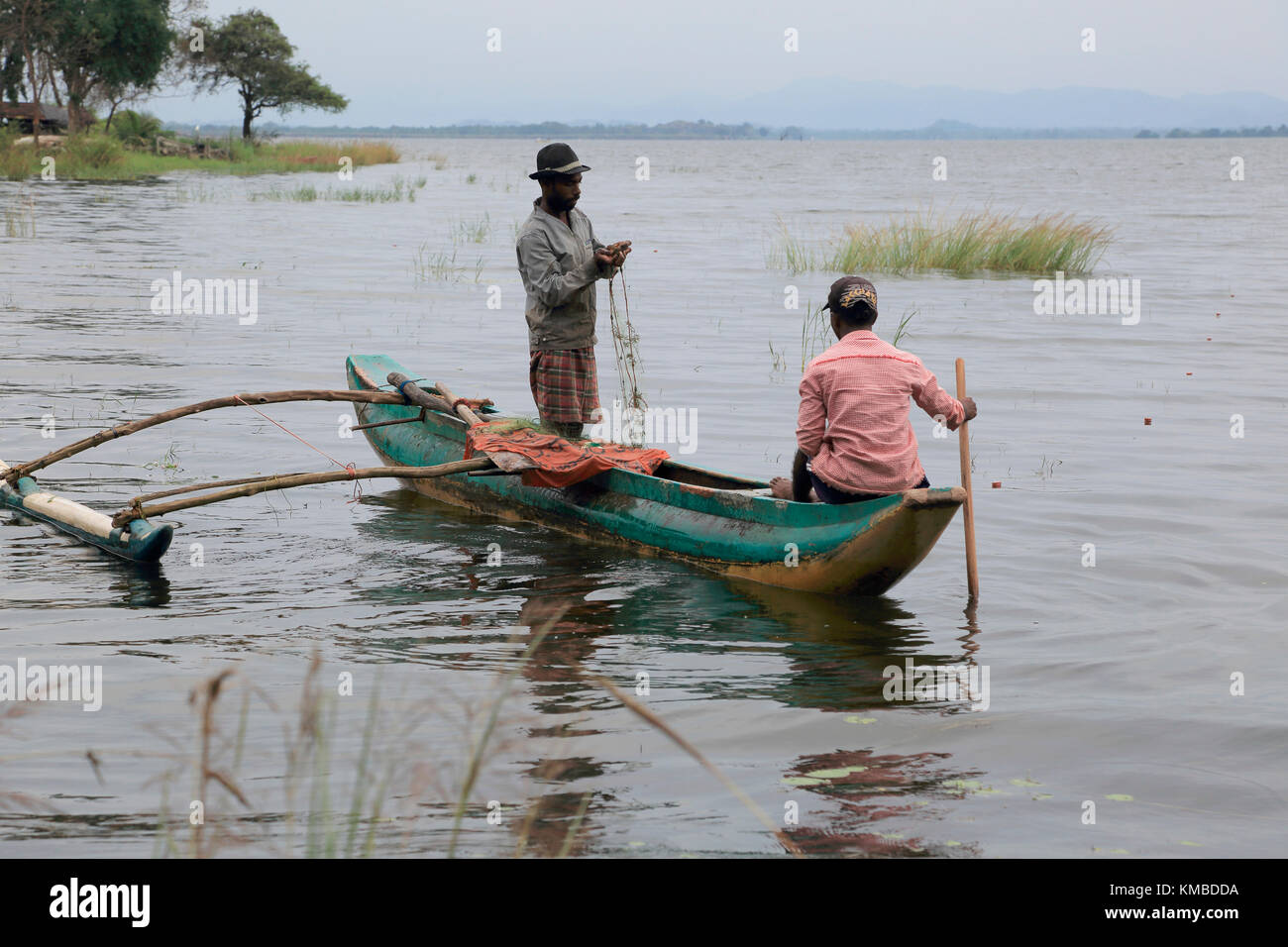 Men fishing from an outrigger canoe, in reservoir lake, Polonnaruwa,  Central Province, Sri Lanka, Asia Stock Photo - Alamy