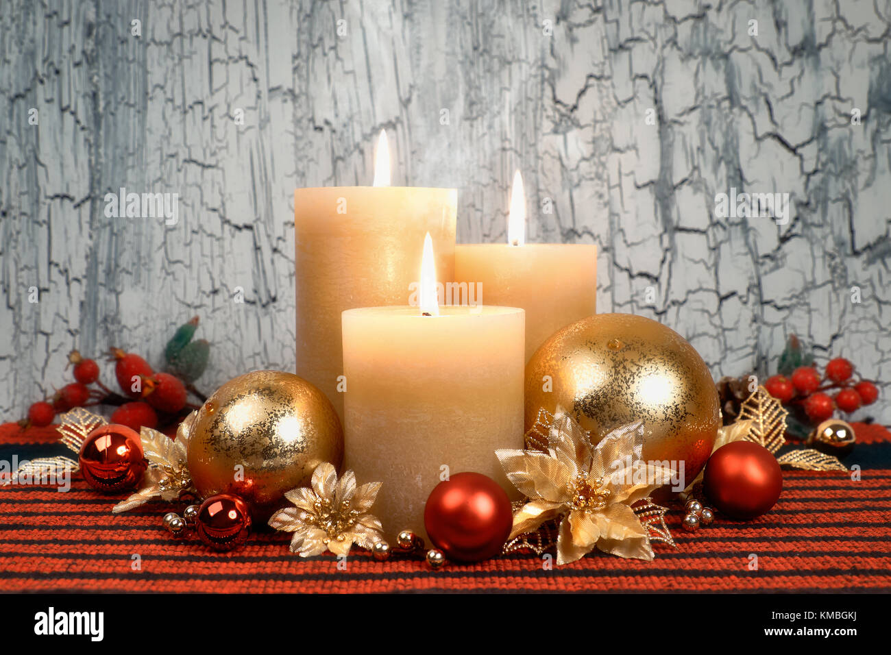 Three burning candles with golden, red and green Christmas Stock Photo