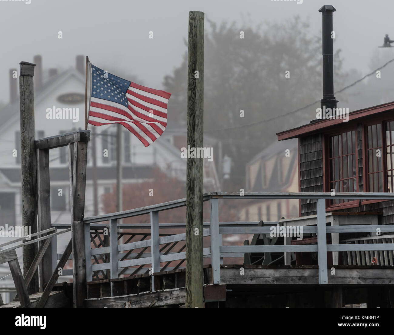 American Flag Blows in Foggy Maine Harbor in the off season Stock Photo