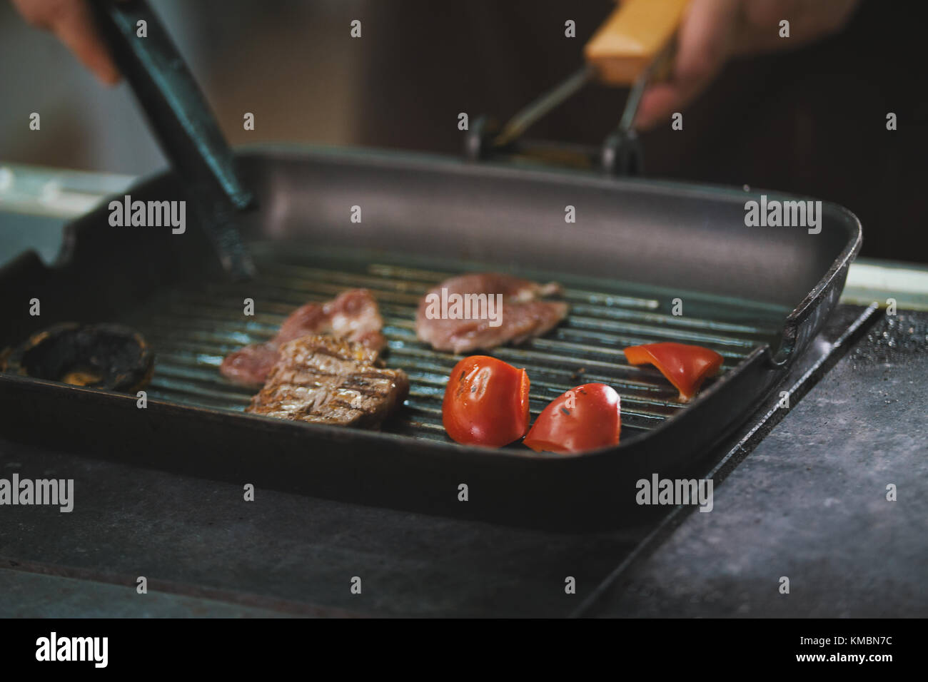 chef is frying meat and vegetables in a pan Stock Photo - Alamy