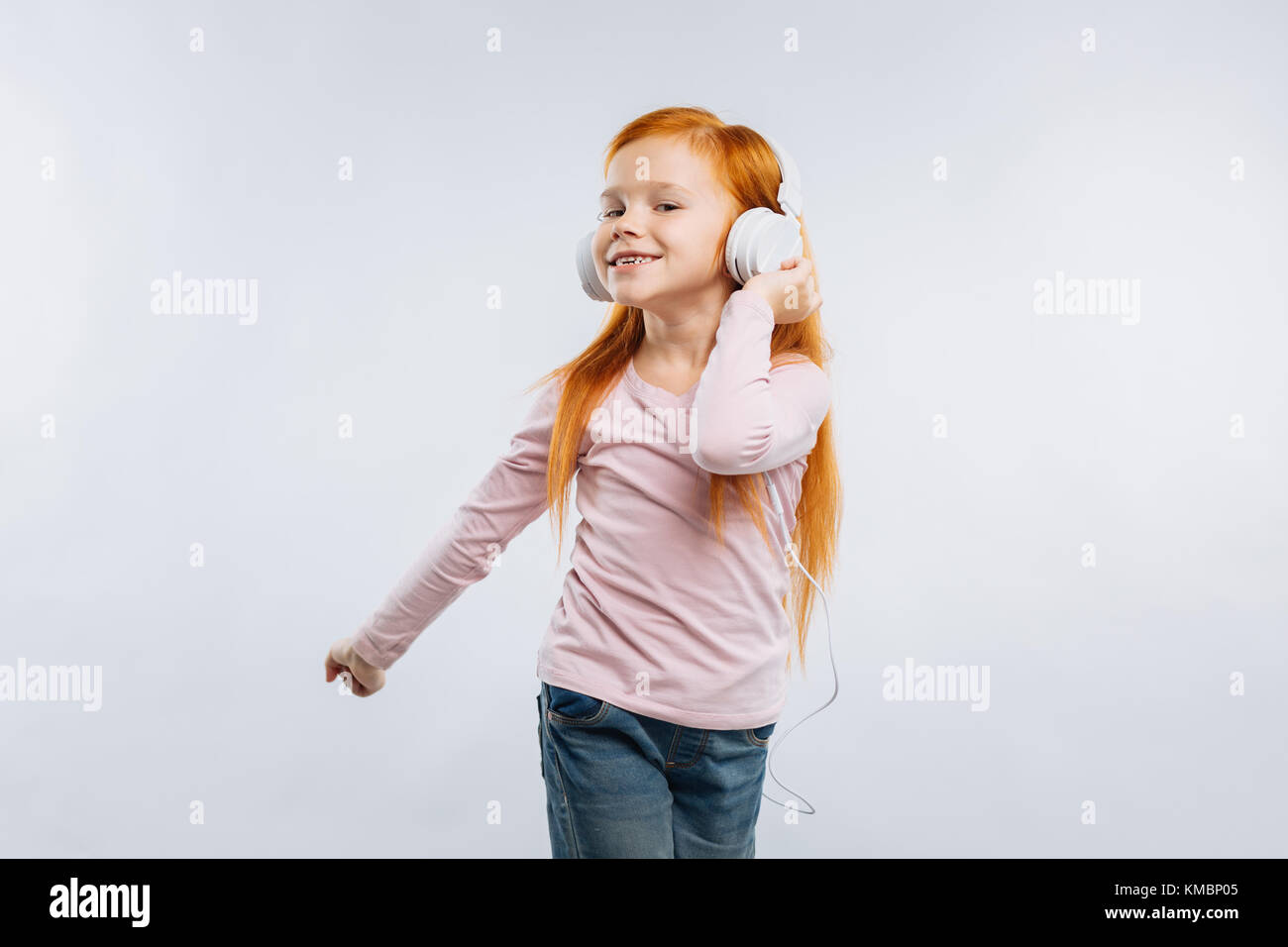Funny child touching her headphones Stock Photo
