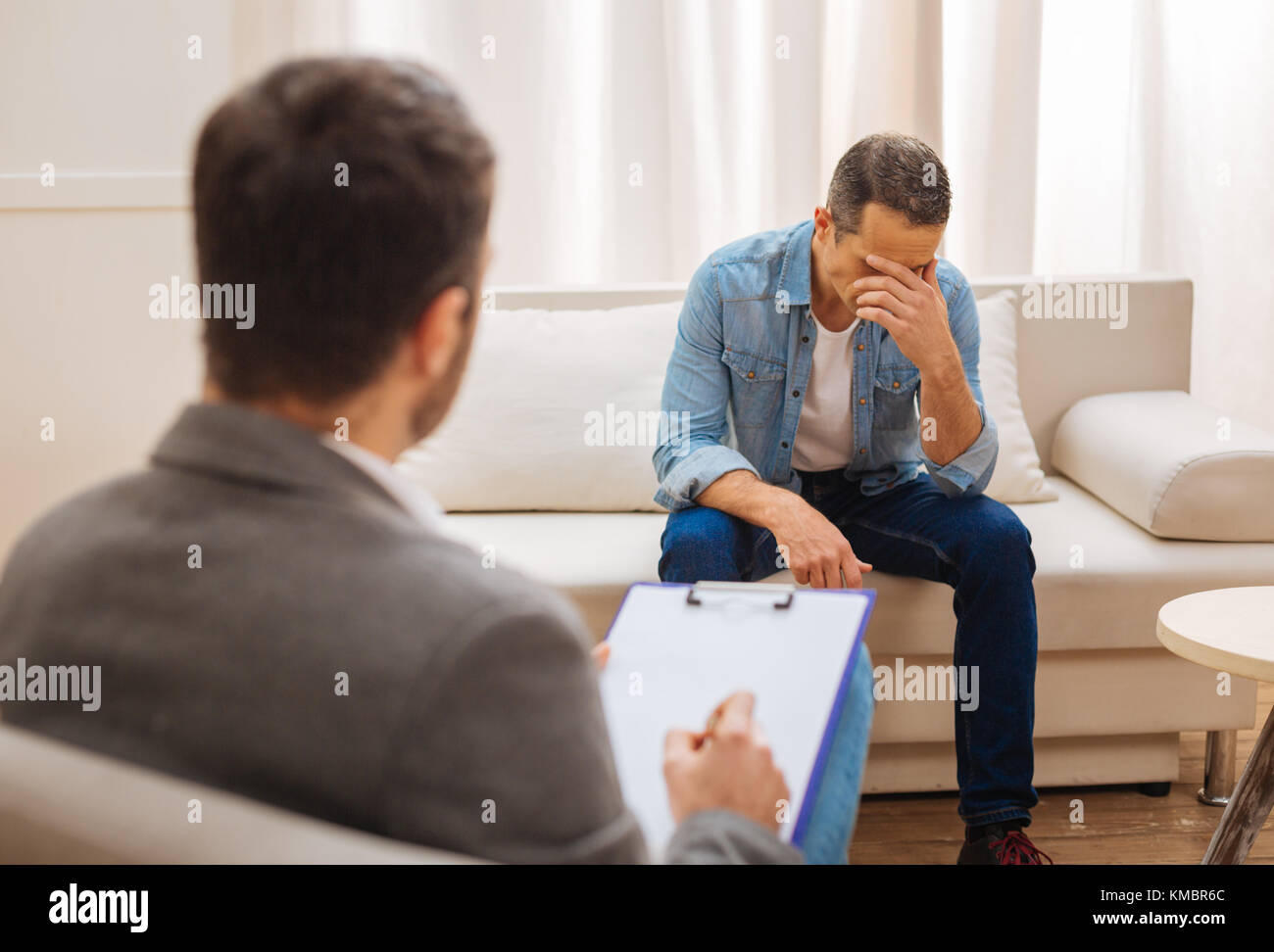 Unhappy  male patient understands his phycological problems Stock Photo