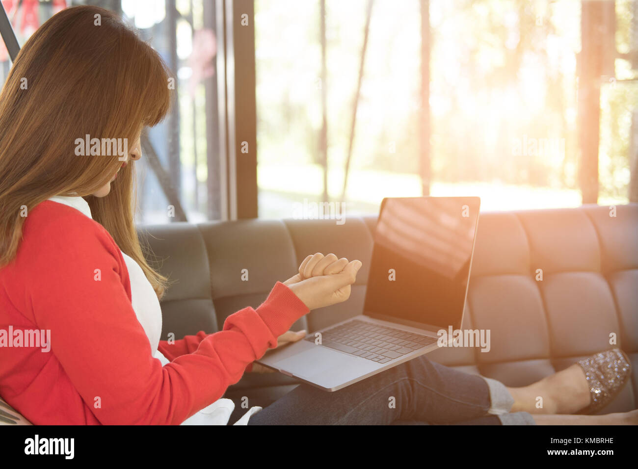 young start up woman raise fist with yes gesture while sitting on sofa at home. freelance female adult  glad with successful project while working wit Stock Photo