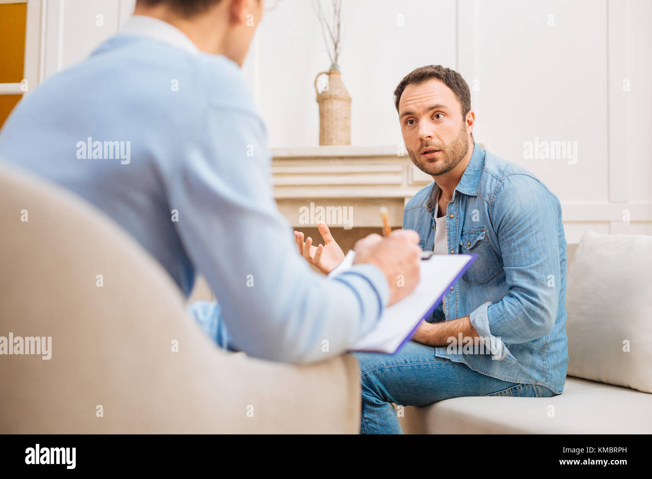 Speechless male patient listening psychologists advice Stock Photo