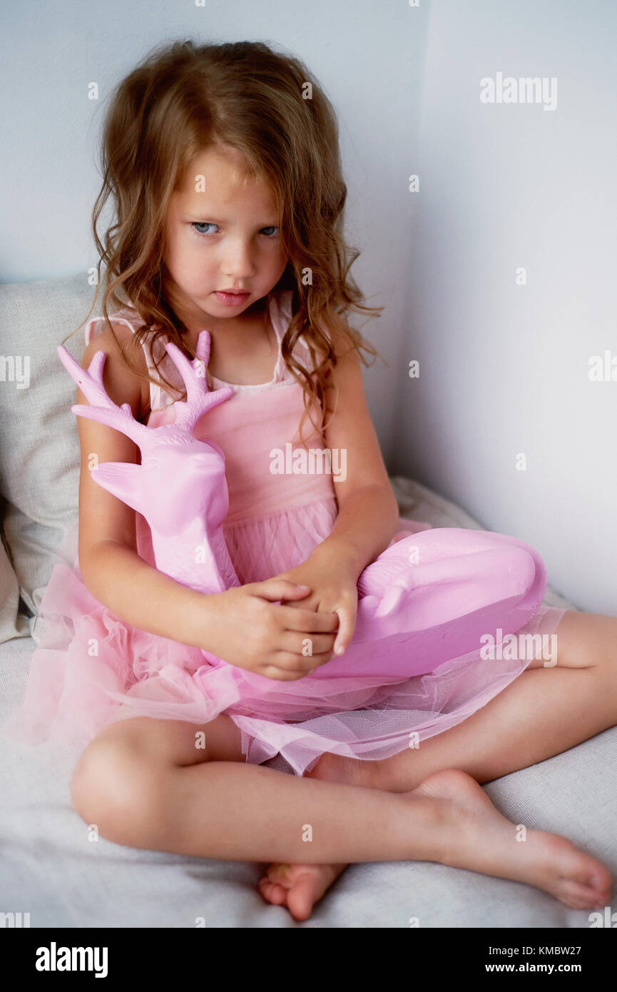 A Lovely Little Girl 4 Years Old In A Pink Dress Plays With Pink Deer The Atmosphere Of Childhood Stock Photo Alamy