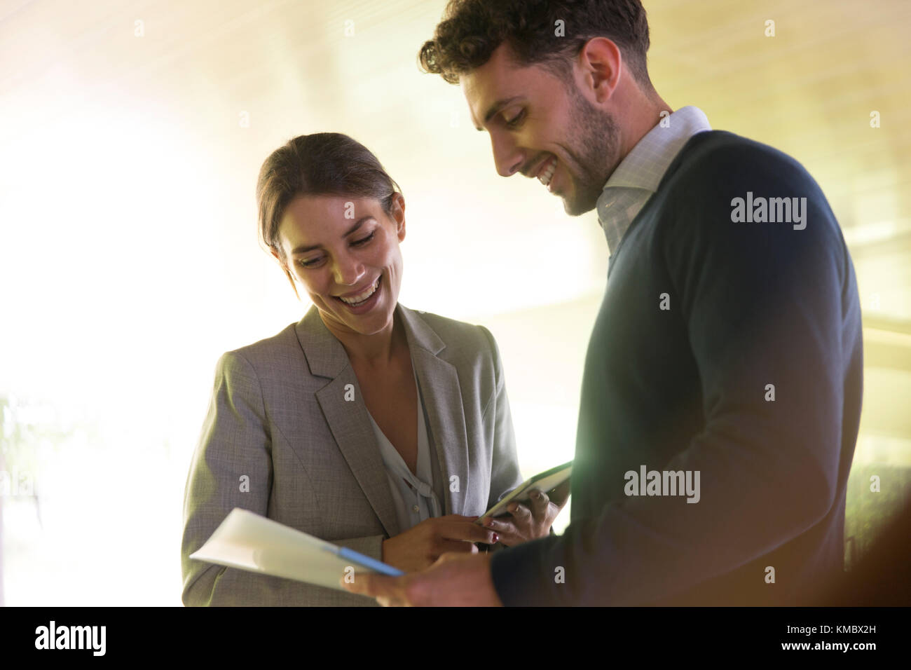 Smiling businessman and businesswoman discussing paperwork Stock Photo