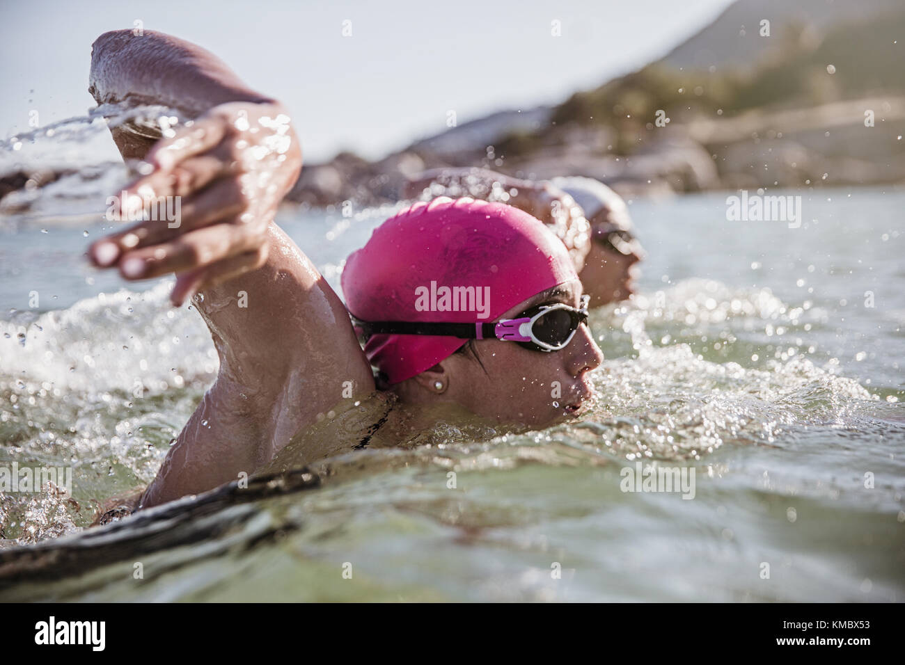 Determined female open water swimmer swimming in sunny ocean Stock ...