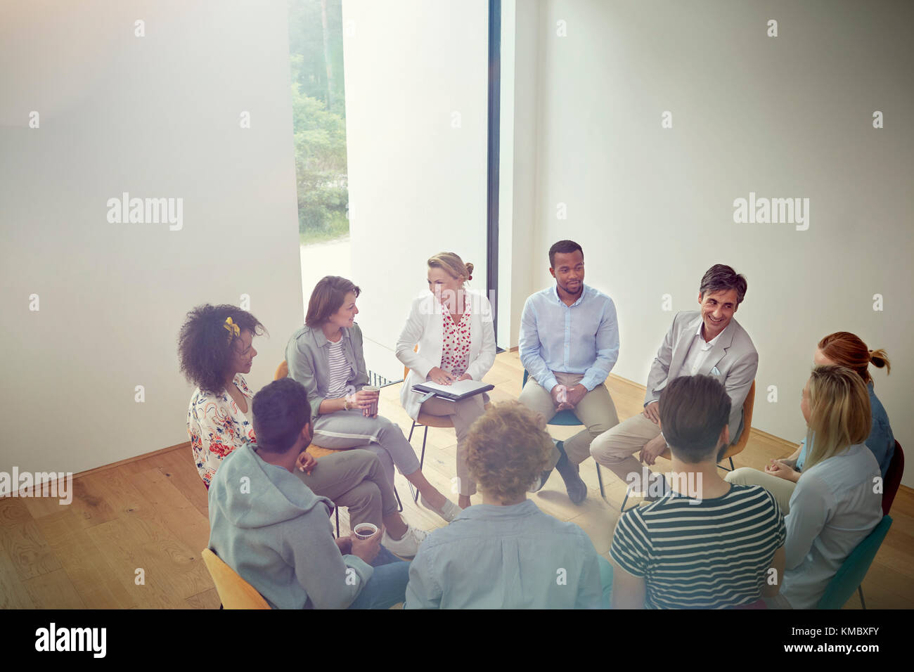 People talking in a circle in group therapy session Stock Photo
