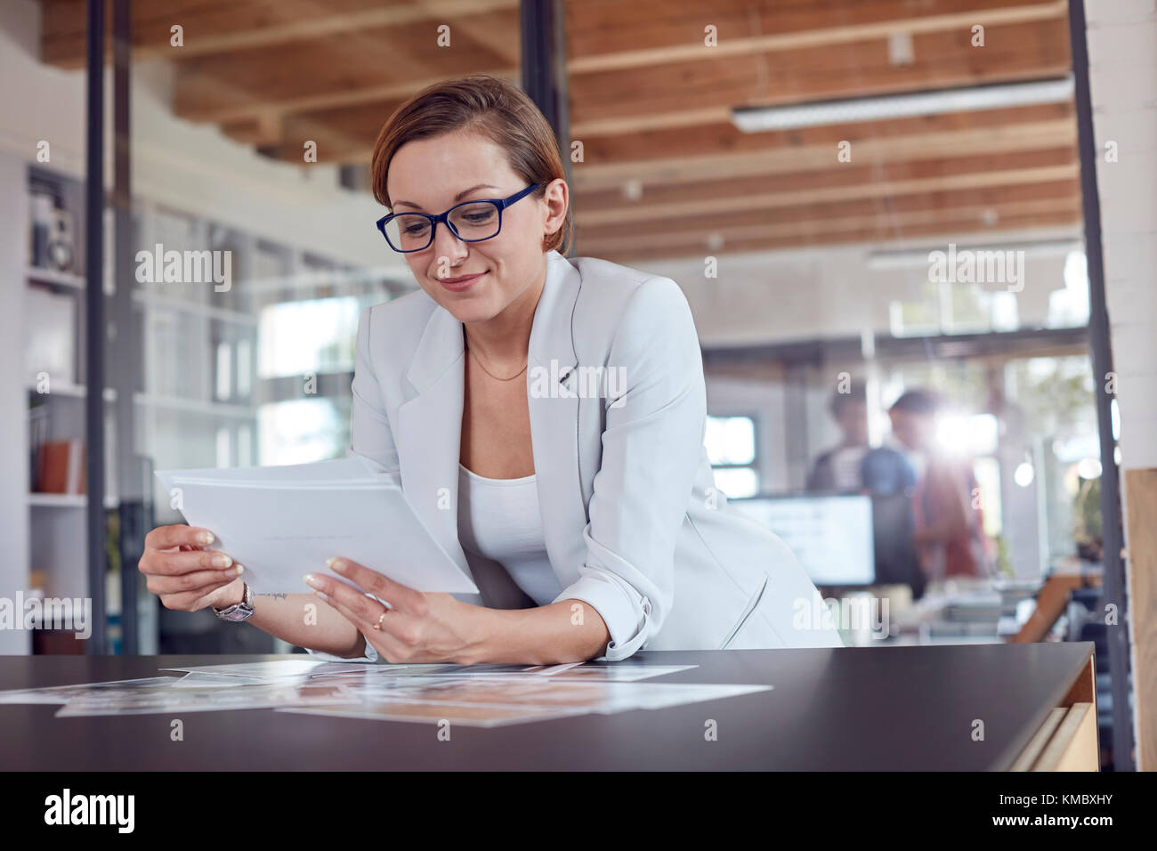 Female design professional reviewing photograph proofs in office Stock Photo