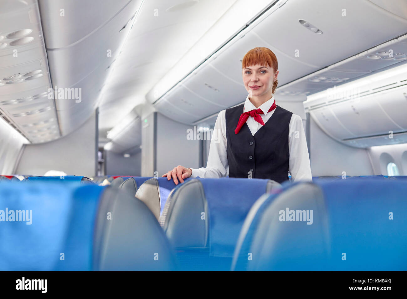 Portrait confident female flight attendant on airplane Stock Photo