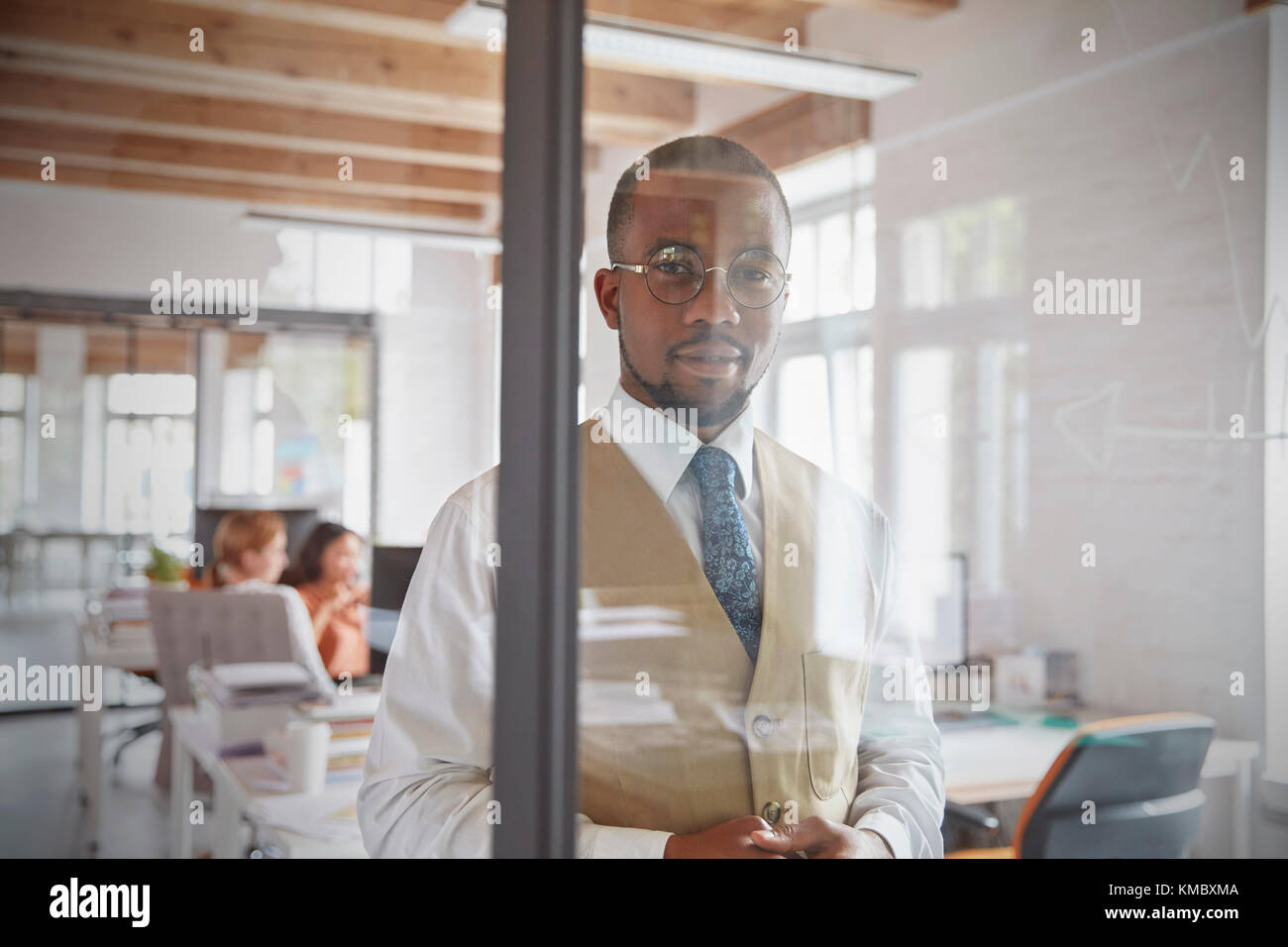 Portrait confident businessman at window in office Stock Photo