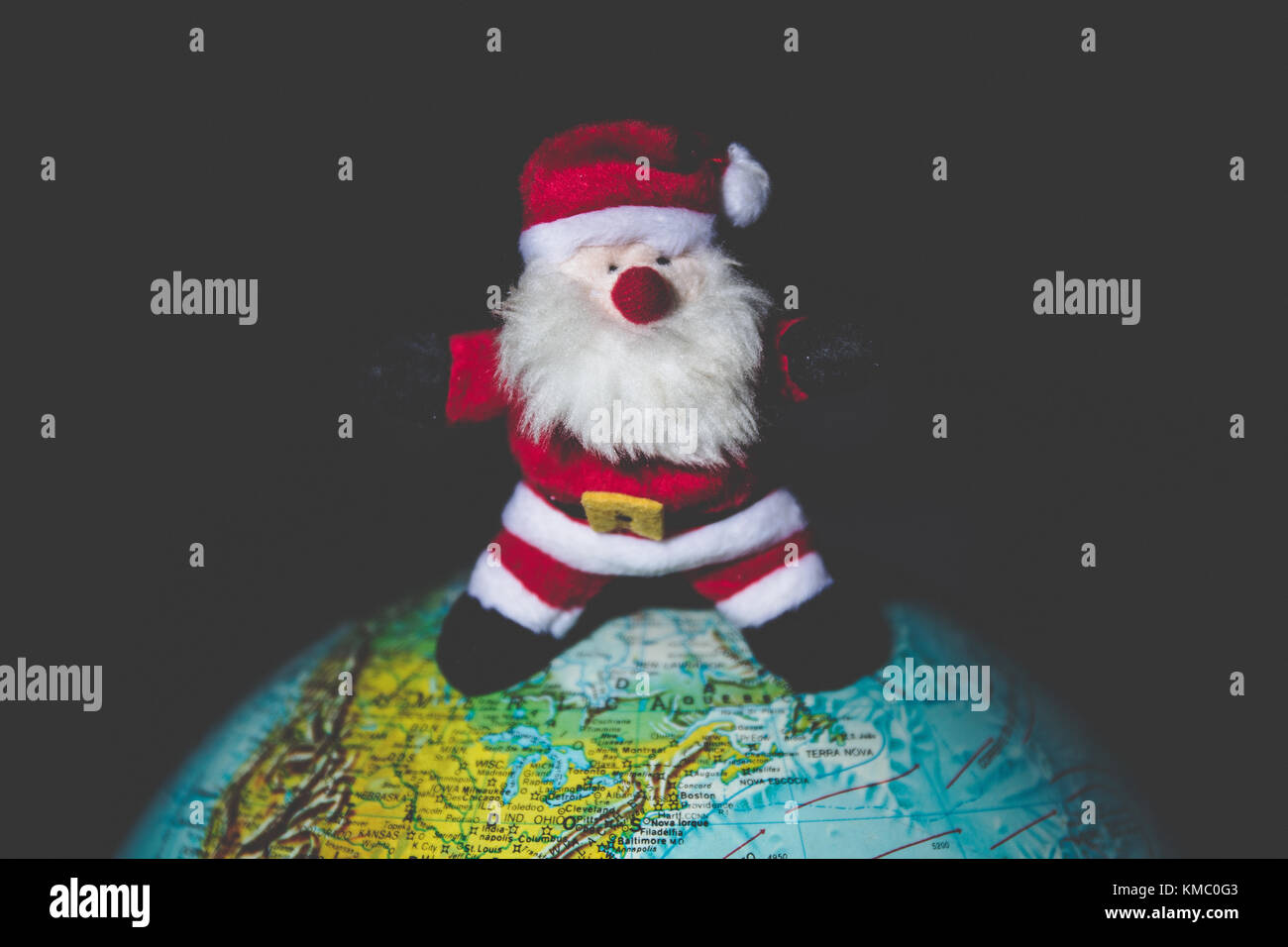 Santa Claus standing on a world globe. Stock Photo