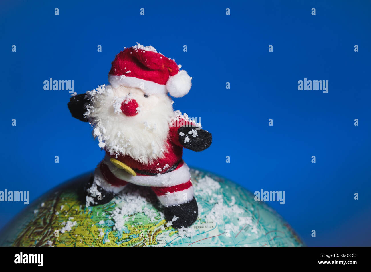 Santa Claus surfing over world globe with snow. Stock Photo