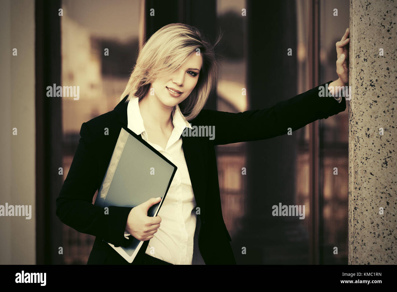 Happy young business woman with a folder at office building Stock Photo ...