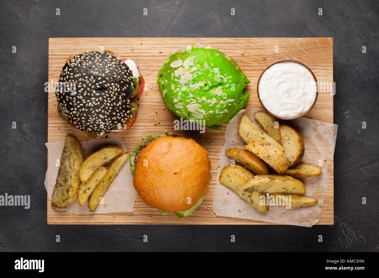 set of three mini homemade Burger with marble beef and vegetables on a wooden Board. the concept of junk food and fast food on dark concrete backgroun Stock Photo