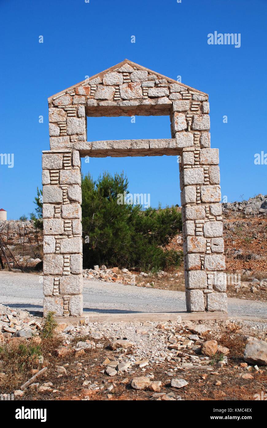 A stone entrance arch in front of the football pitch at Emborio on the Greek island of Halki. Stock Photo