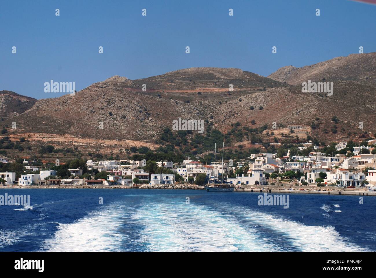 The wake from Dodekanisos Seaways catamaran ferry Dodekanisos Express departing Livadia harbour on the Greek island of Tilos on June 12, 2010. Stock Photo