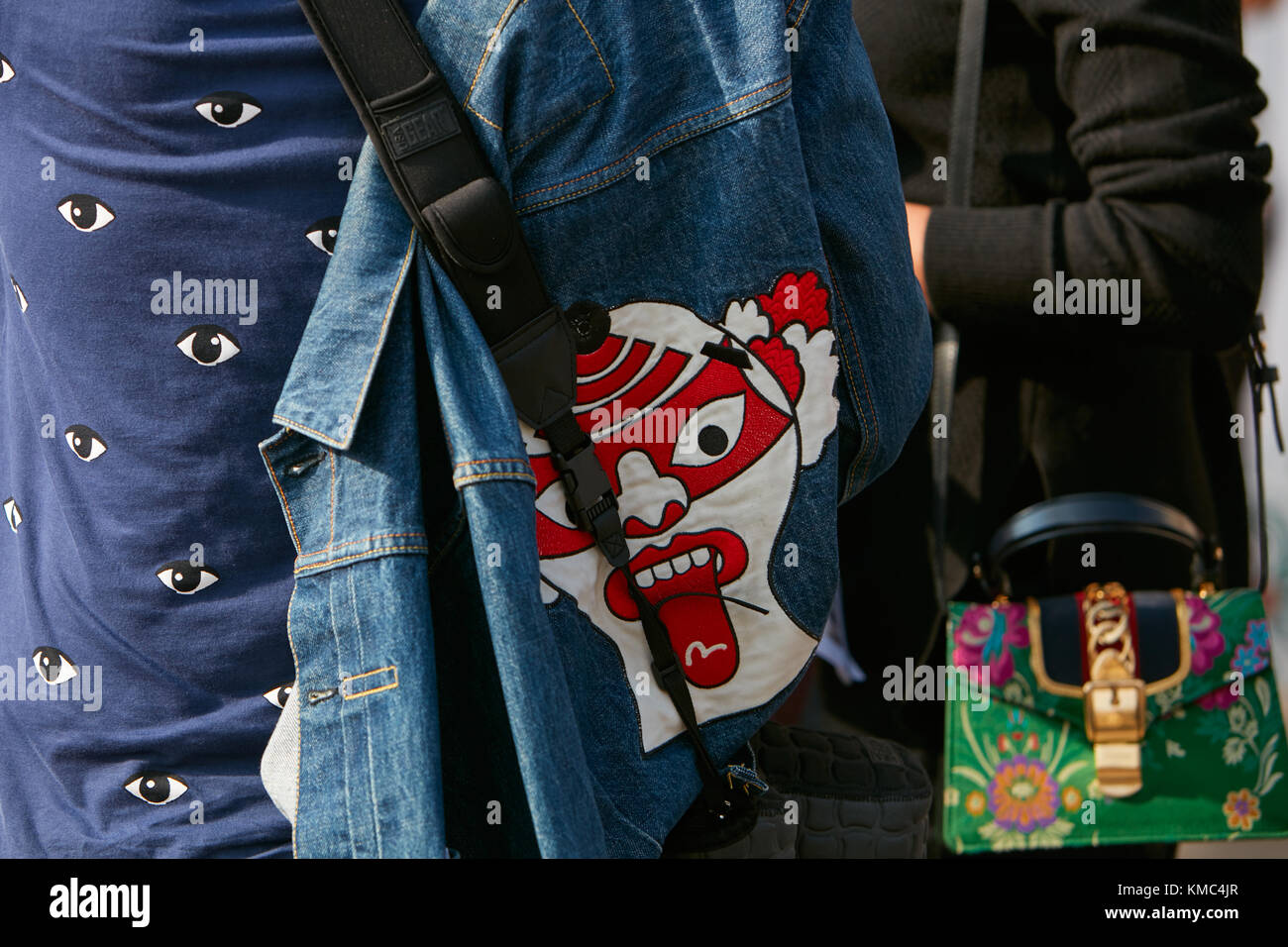 MILAN - SEPTEMBER 23: Woman with blue jeans jacket with white and red clown head design before Gabriele Colangelo fashion show, Milan Fashion Week str Stock Photo