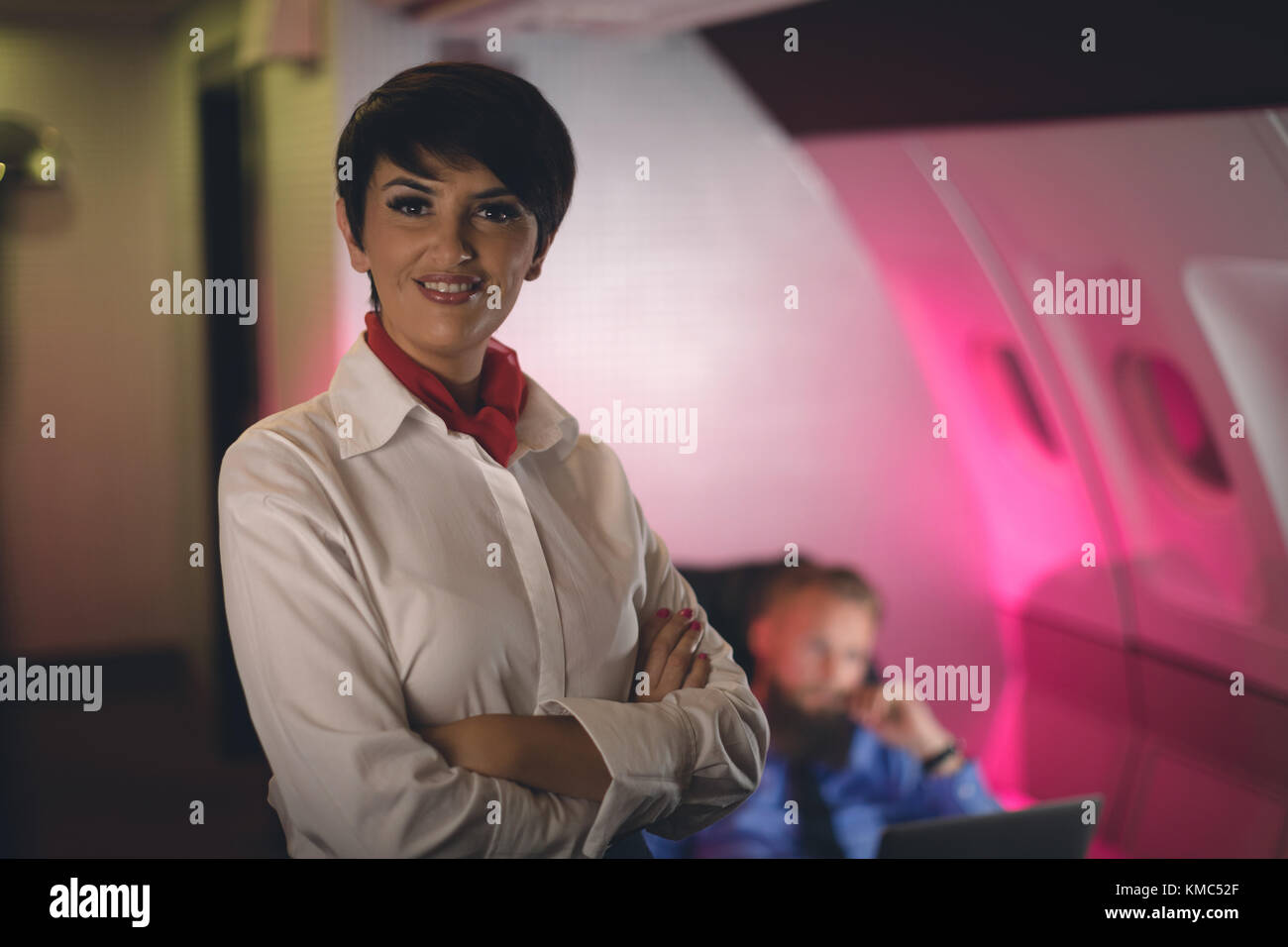 Air hostess standing with arms crossed Stock Photo