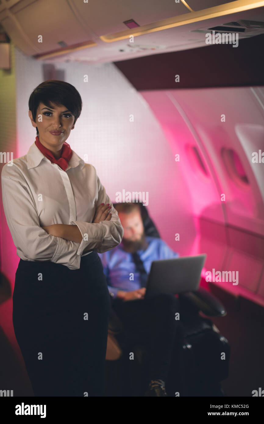Air hostess standing with arms crossed Stock Photo