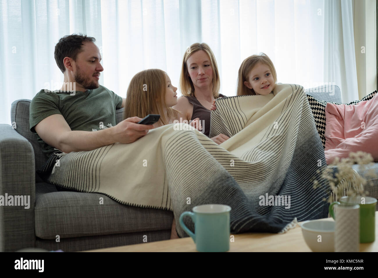 Family watching television in living room Stock Photo