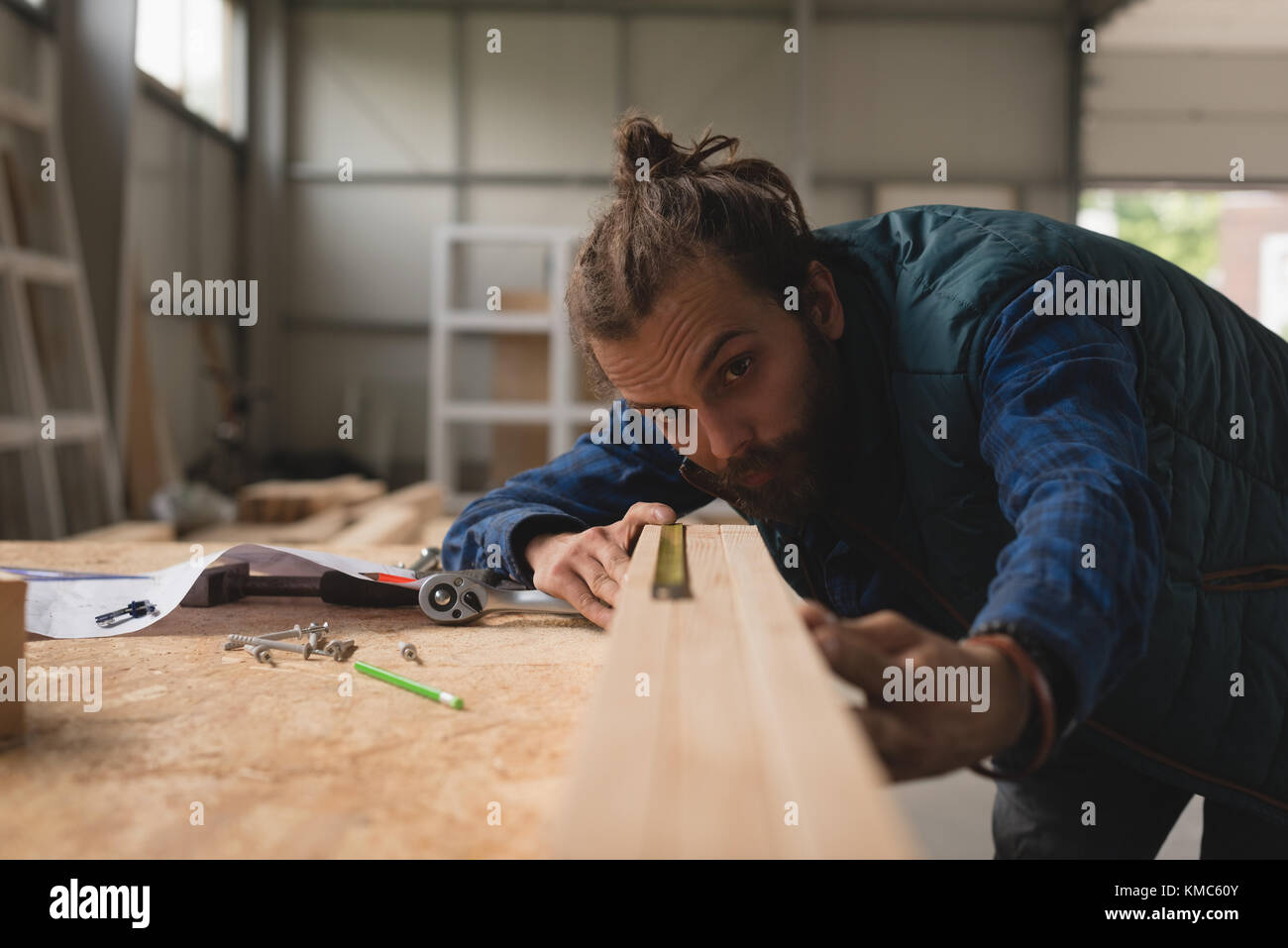 Carpenter measuring wooden slab with scale Stock Photo