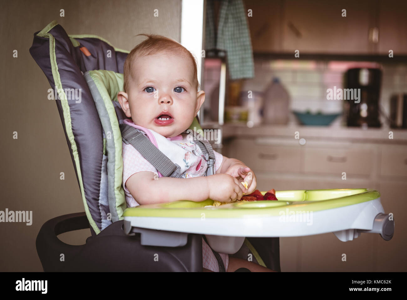 Cute baby sitting in high chair Stock Photo