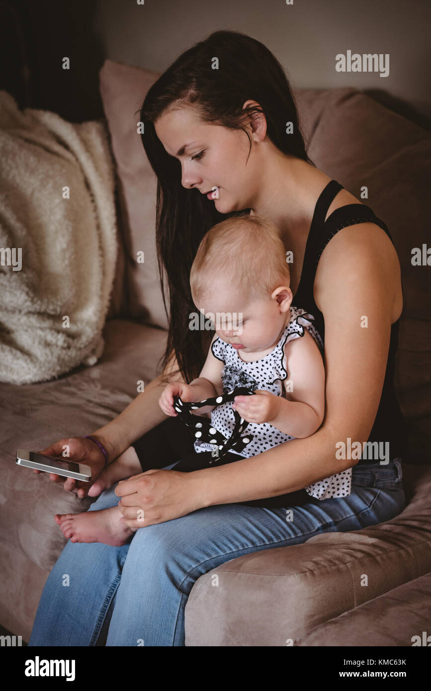 Mother sitting with her baby on sofa Stock Photo