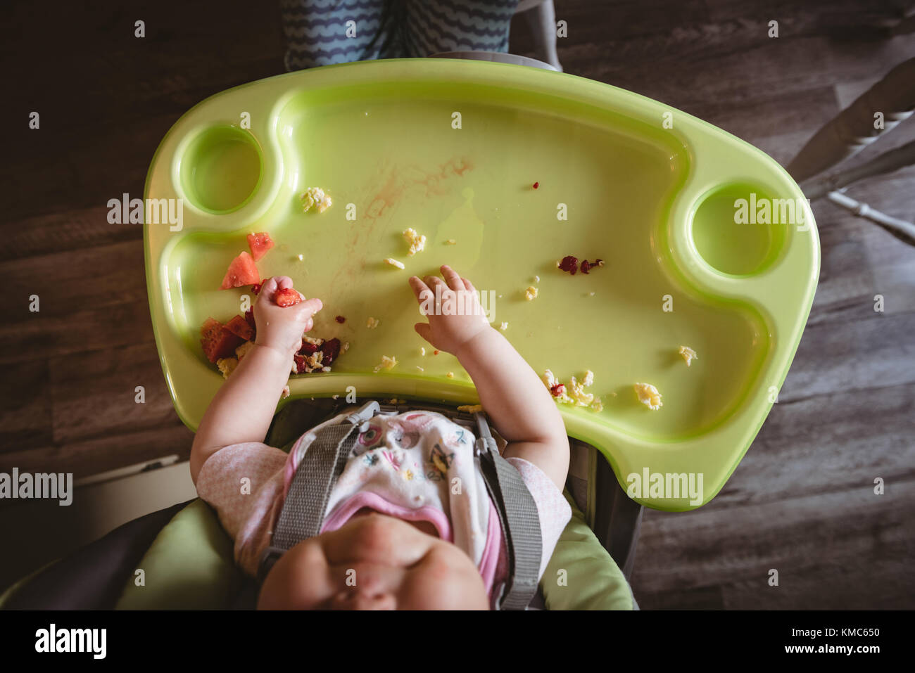 Overhead of baby sitting in high chair Stock Photo