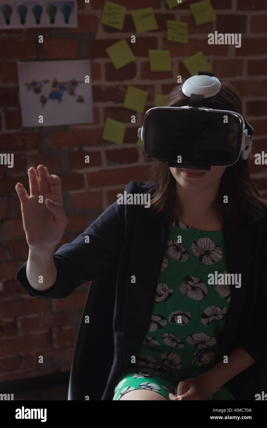 Female executives using virtual reality headset in office Stock Photo ...