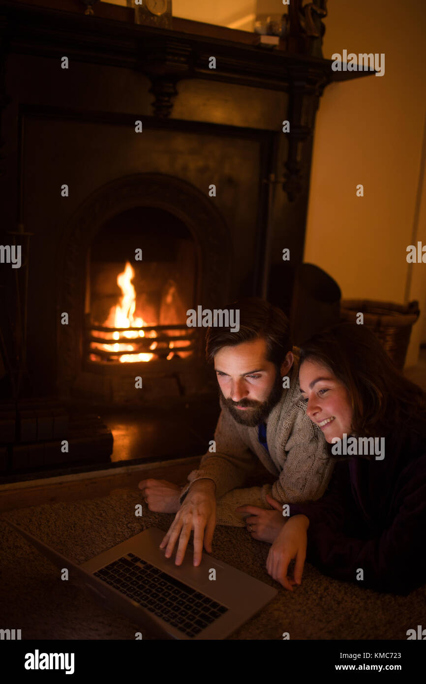 Smiling couple using laptop in living room Stock Photo - Alamy