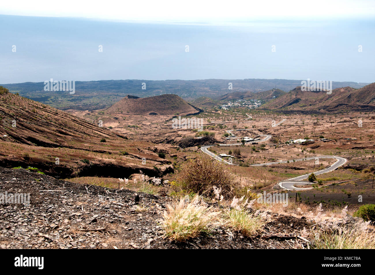 The road through a volcanic landscape that leads to the vast crater of ...