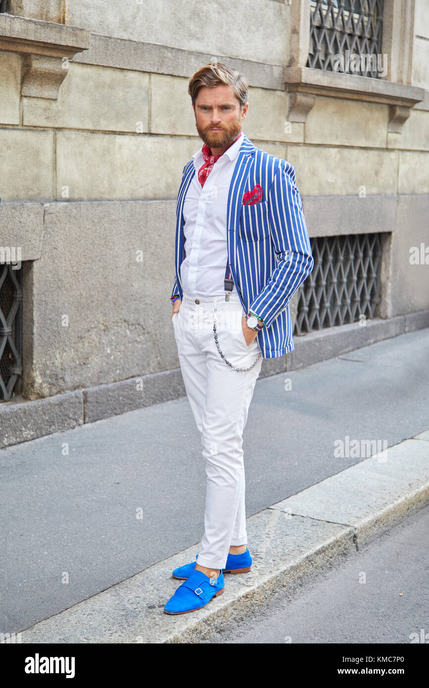 MILAN - SEPTEMBER 23: Man with blue shoes and white and blue striped jacket before Ermanno Scervino fashion show, Milan Fashion Week street style on S Stock Photo
