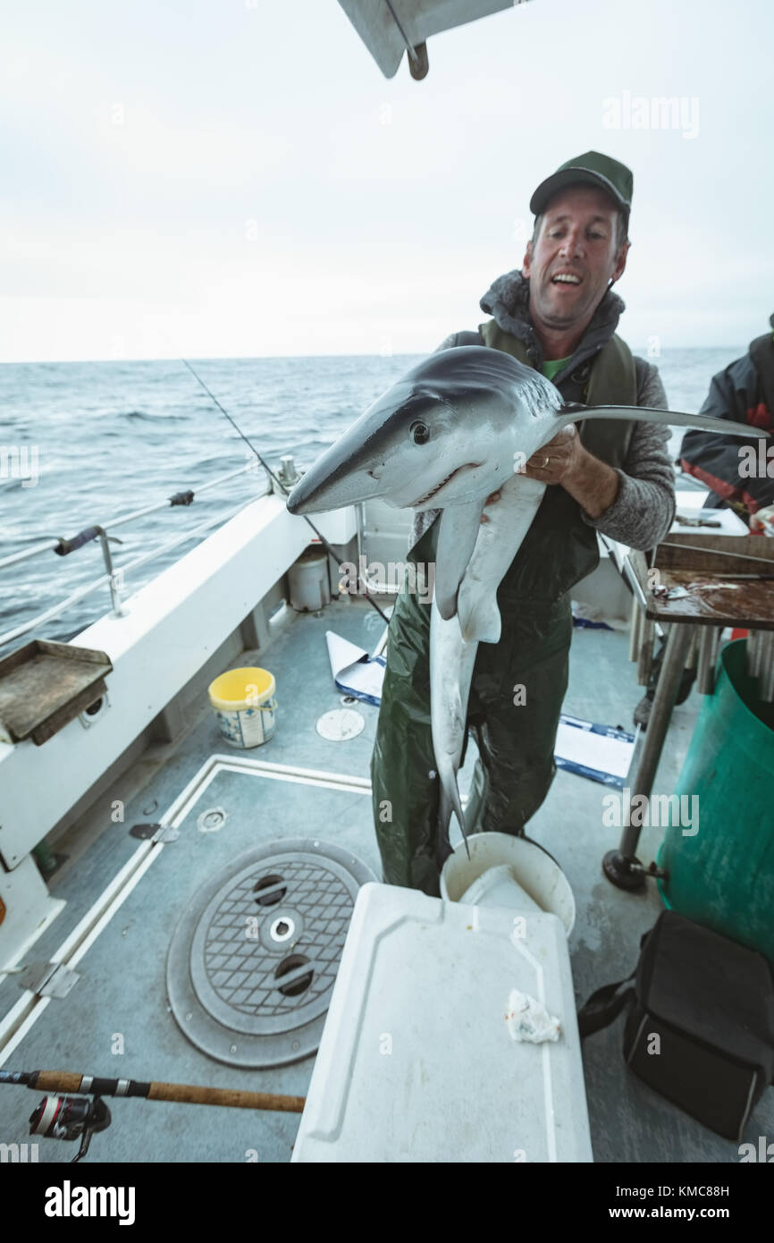 Fisherman holding shark fish Stock Photo Alamy