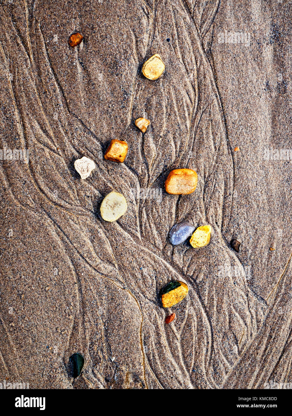 Pebbles and Patterns in the Sand left by the Receding Tide at Cayton Bay Scarborough North Yorkshire England Stock Photo