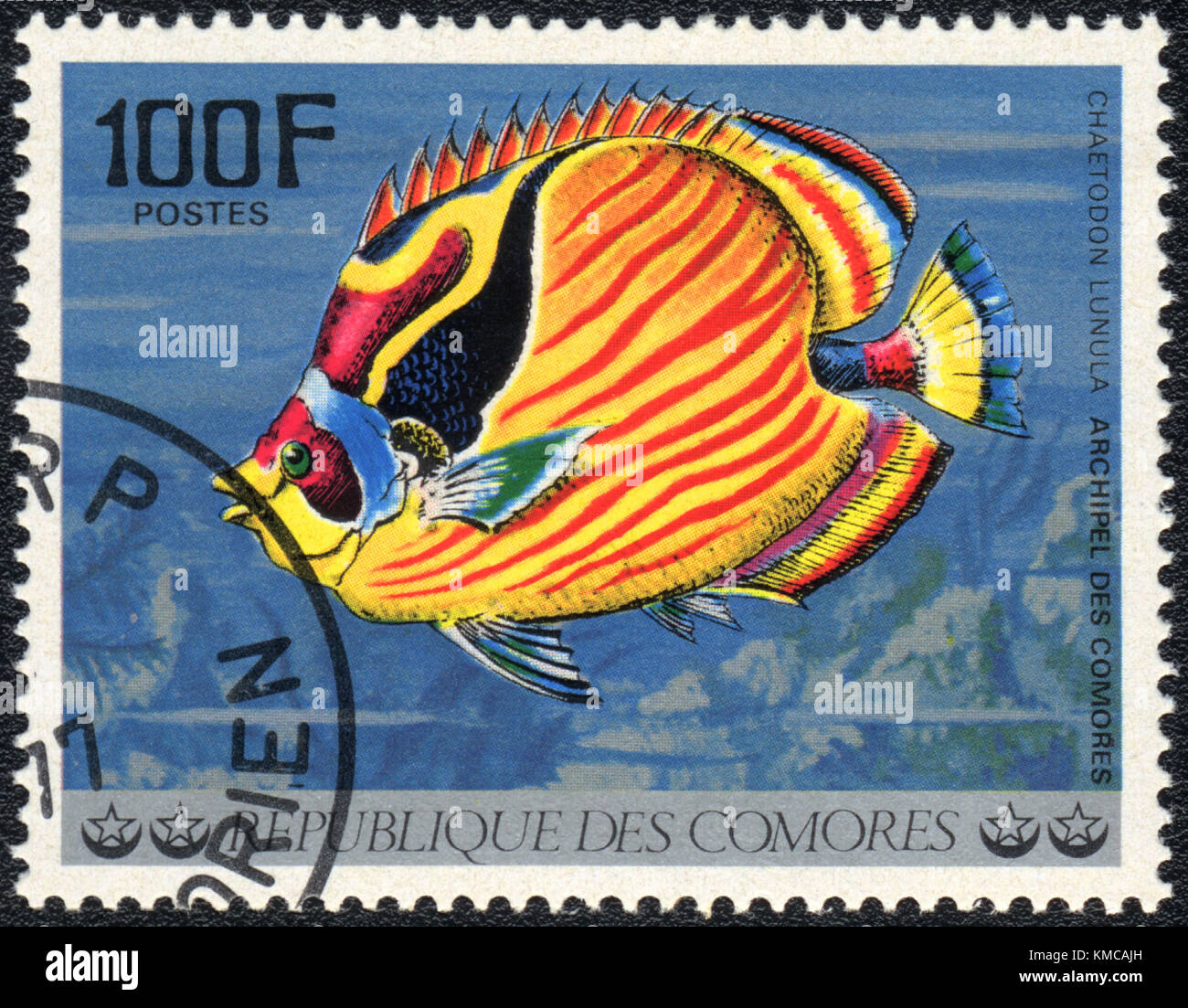 A stamp printed in COMOROS shows  a Raccoon butterflyfish (Chaetodon lunuca), series 'Tropical Fishes', circa 1977 Stock Photo