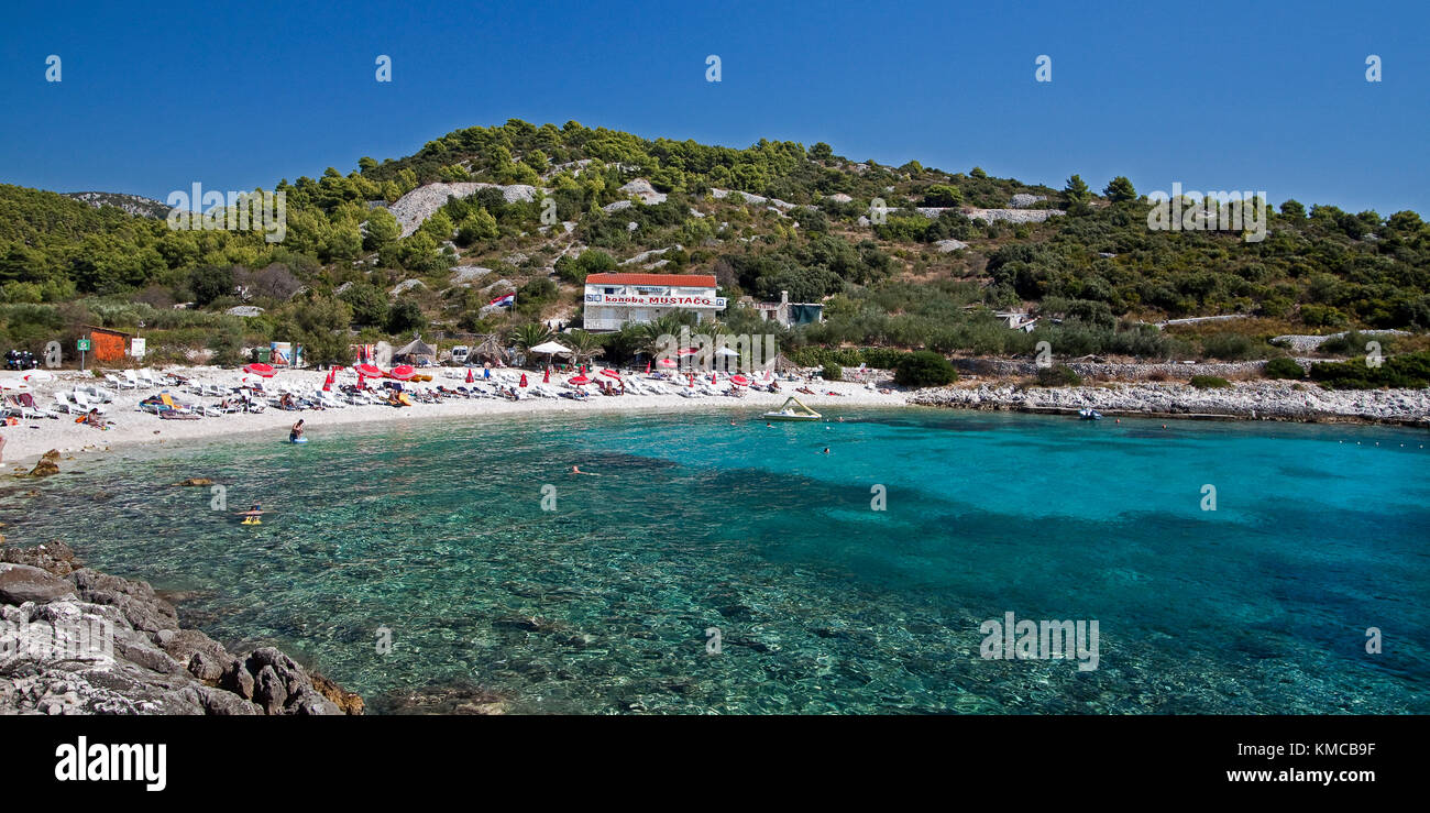 Cristal clear water at  Hvar beach  Pokonji dol with  Konoba Mustaco Restaurant , Croatia Stock Photo