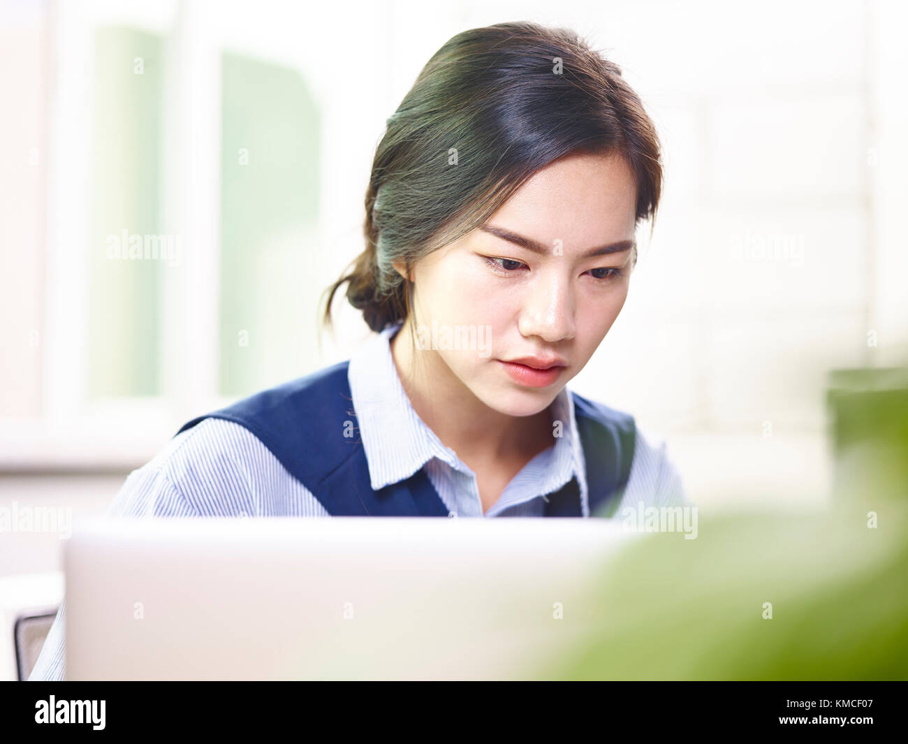 close-up of face of a young asian businesswoman working in office sitting at desk using laptop computer. Stock Photo