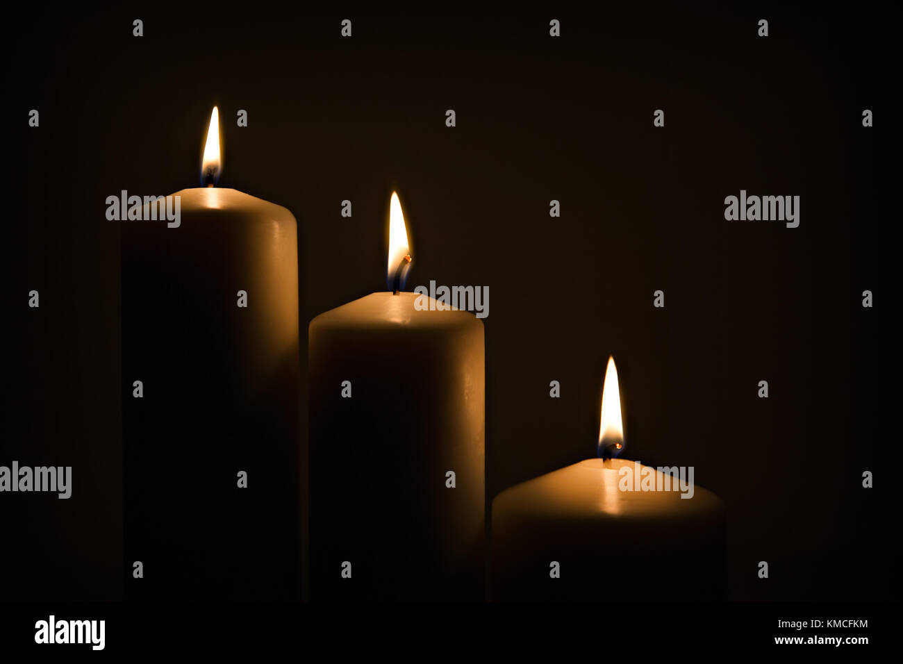 Candles burning burning brightly in the dark background Stock Photo Alamy